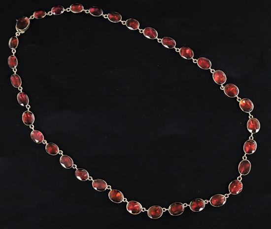 A Victorian gold and foiled back oval cut garnet necklace, approx. 36cm.